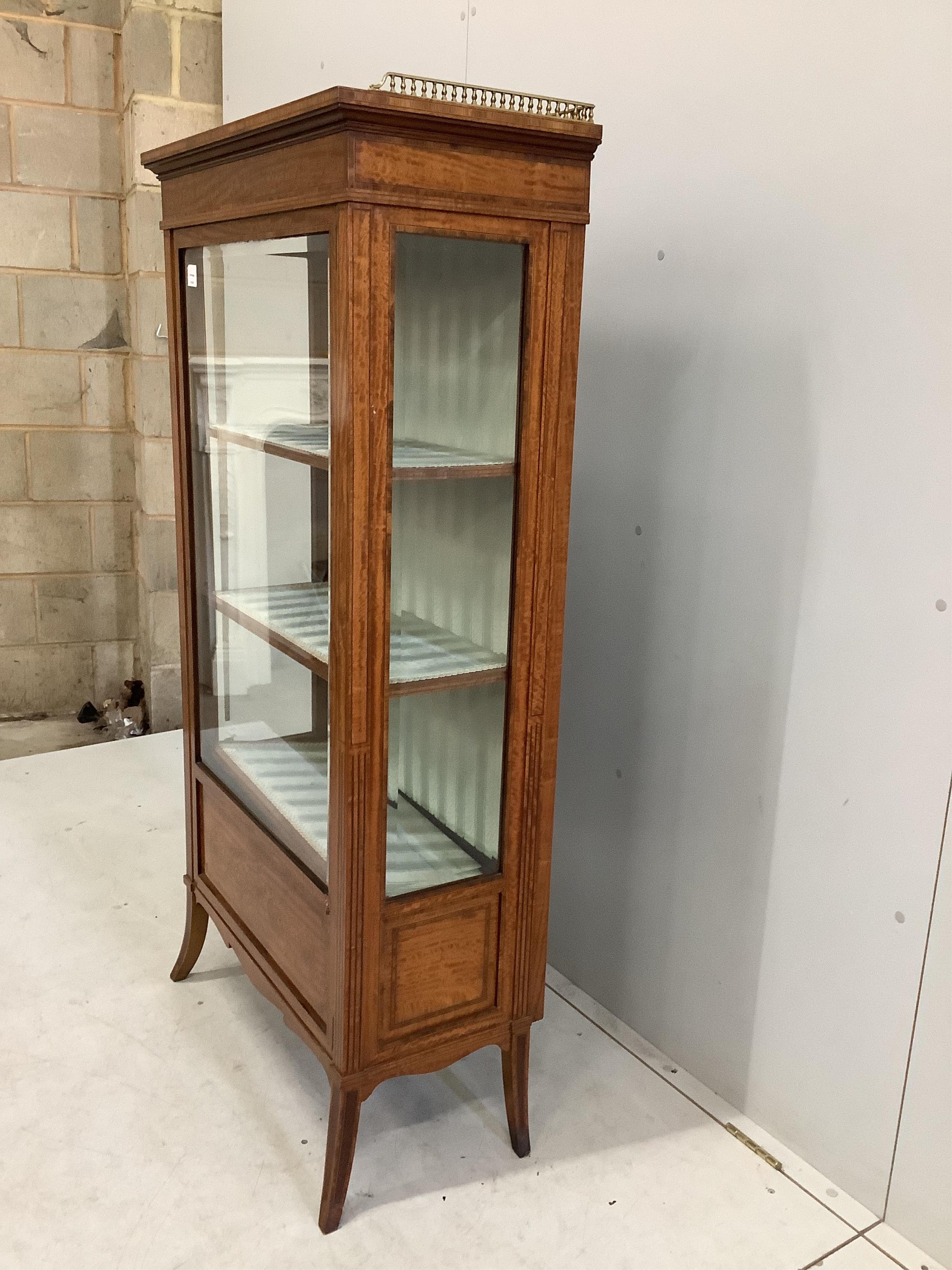 An Edwardian marquetry inlaid satinwood vitrine, bears Maple & Co. trade label, width 73cm, depth 36cm, height 148cm. Condition - good, locked, no key